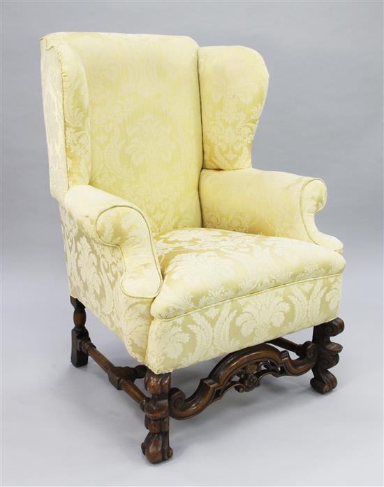 An 18th century style carved walnut wingback armchair,
